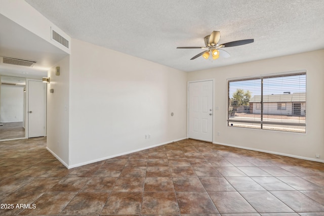 spare room with visible vents, a textured ceiling, baseboards, and ceiling fan