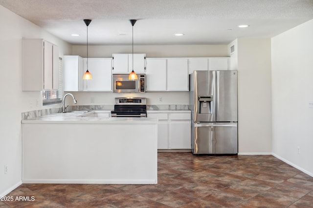 kitchen featuring appliances with stainless steel finishes, white cabinetry, light countertops, and a sink