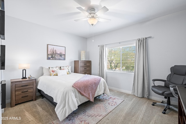 bedroom featuring baseboards, light colored carpet, and a ceiling fan