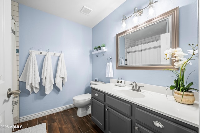 full bath with visible vents, baseboards, toilet, wood finished floors, and vanity