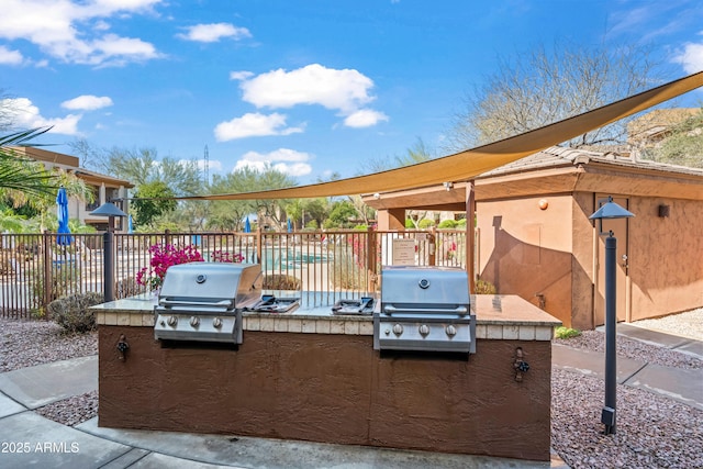 view of patio with a grill, exterior kitchen, and fence