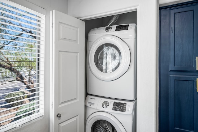 clothes washing area with laundry area and stacked washing maching and dryer