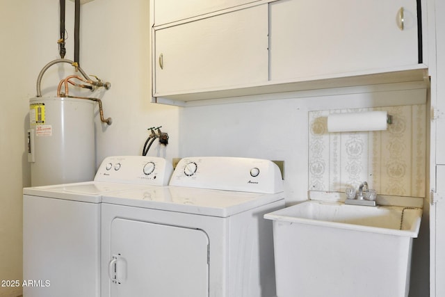 laundry area featuring separate washer and dryer, cabinet space, electric water heater, and a sink