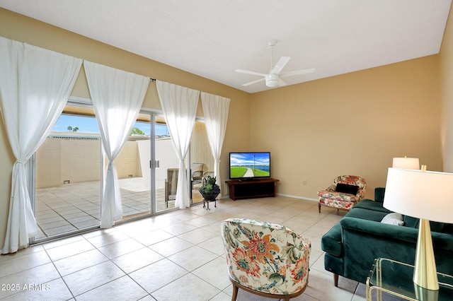 living area with tile patterned floors, a ceiling fan, and baseboards