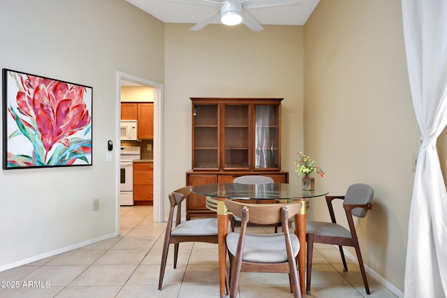 dining area featuring light tile patterned floors, baseboards, and ceiling fan