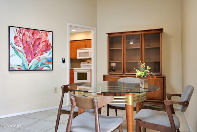 dining space featuring baseboards and light tile patterned flooring