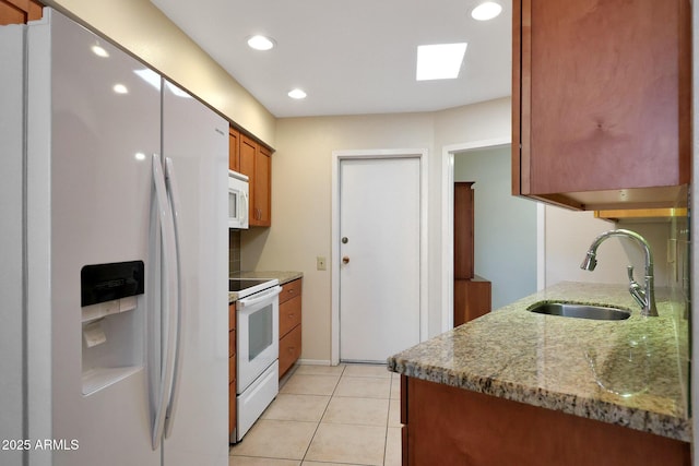 kitchen with a sink, recessed lighting, white appliances, brown cabinetry, and light tile patterned floors