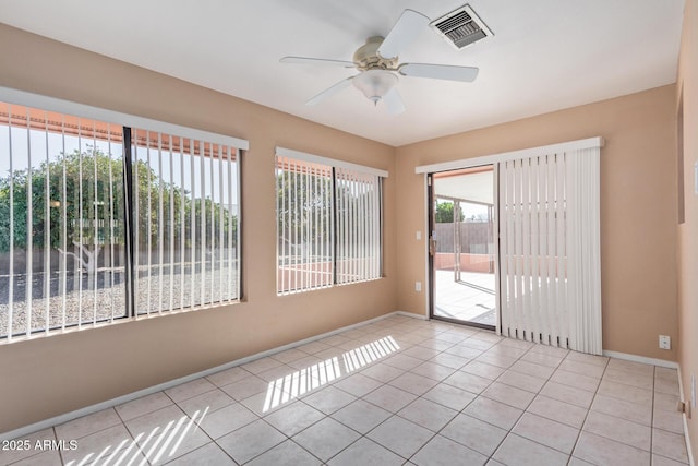 tiled spare room featuring ceiling fan