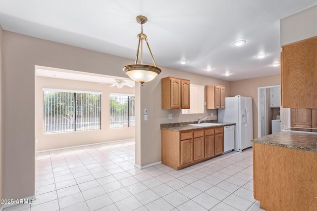 kitchen with decorative light fixtures, washer / clothes dryer, sink, light tile patterned floors, and white appliances