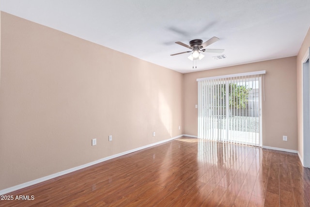 empty room with ceiling fan and dark hardwood / wood-style flooring