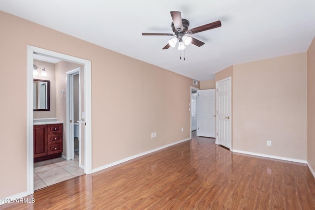 unfurnished bedroom featuring ensuite bathroom, ceiling fan, and light hardwood / wood-style floors