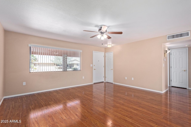 unfurnished room featuring a textured ceiling, dark wood-type flooring, and ceiling fan