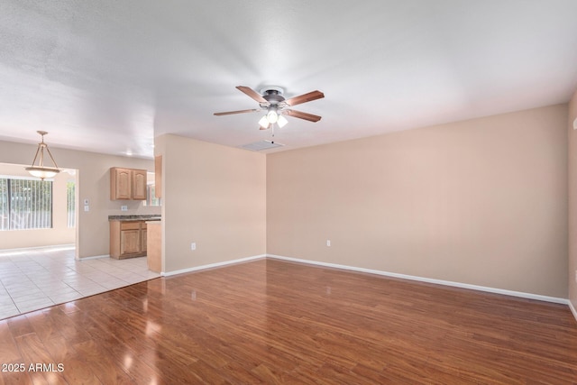 unfurnished living room featuring light hardwood / wood-style floors and ceiling fan