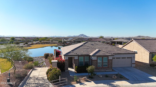 view of front facade featuring a garage and a water and mountain view