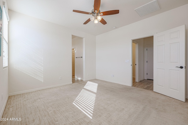 empty room featuring light colored carpet and ceiling fan