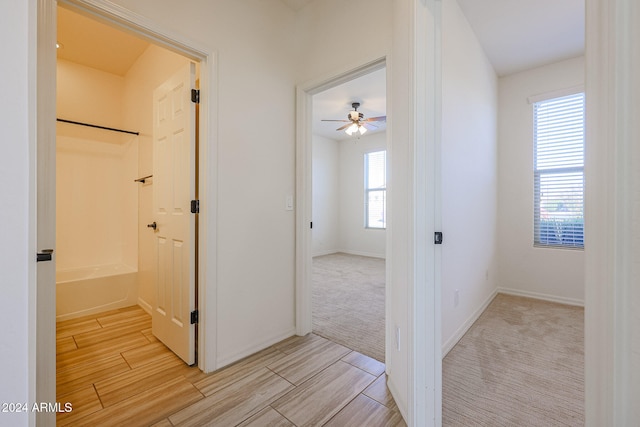 hallway featuring light colored carpet