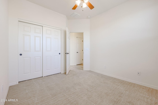 unfurnished bedroom featuring light carpet, ceiling fan, and a closet