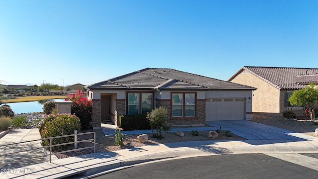 view of front of property featuring a garage and a water view