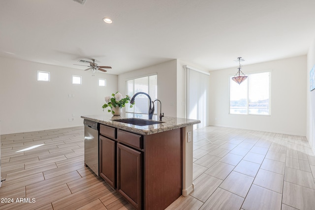 kitchen with a center island with sink, sink, ceiling fan, stainless steel dishwasher, and pendant lighting