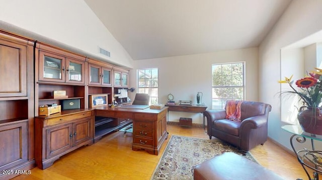 home office featuring lofted ceiling, plenty of natural light, and light wood finished floors