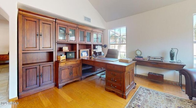 office area featuring visible vents, light wood-style flooring, and high vaulted ceiling