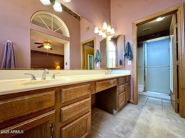 bathroom with visible vents, double vanity, a sink, tile patterned floors, and toilet