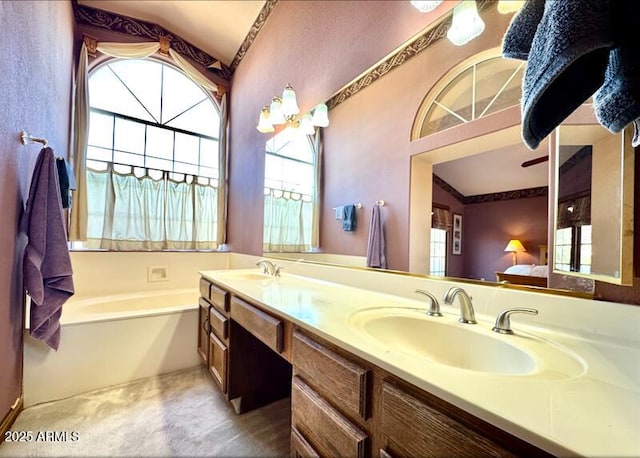 ensuite bathroom featuring a sink, connected bathroom, a garden tub, and double vanity