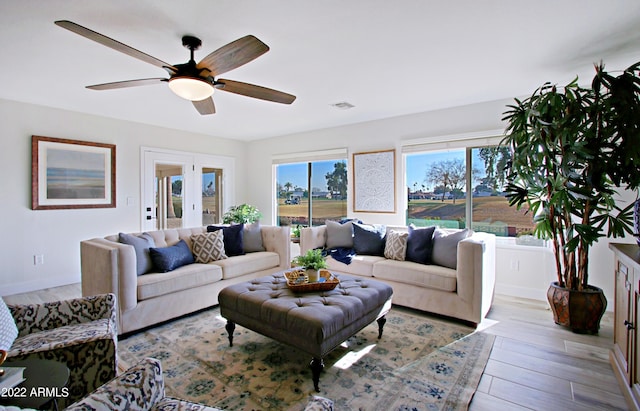 living room with light hardwood / wood-style floors and ceiling fan