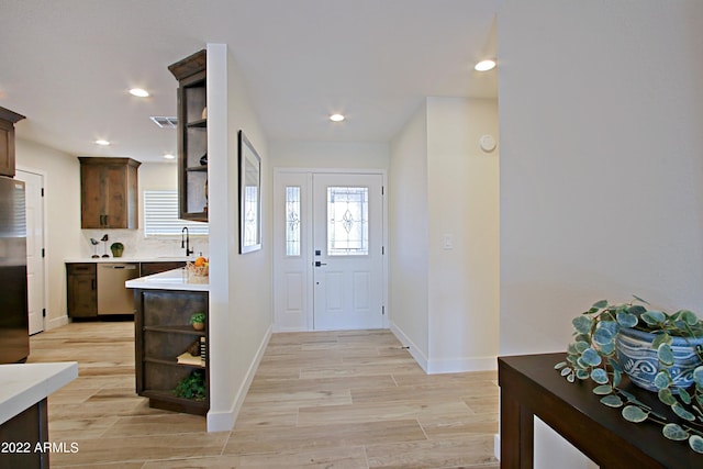 foyer entrance with sink and light wood-type flooring