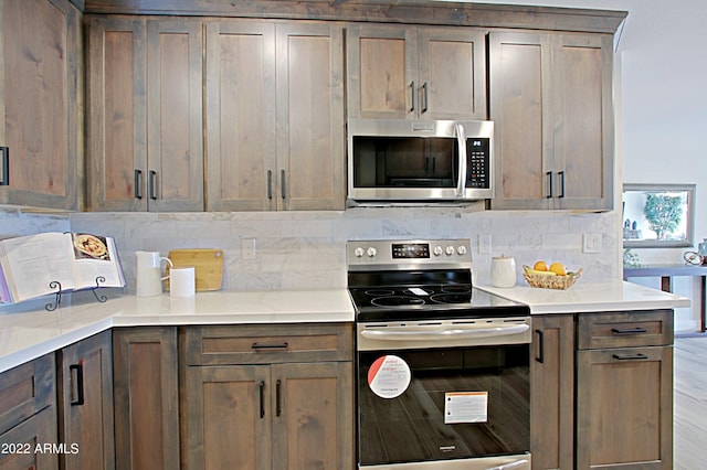 kitchen with light hardwood / wood-style floors, tasteful backsplash, and stainless steel appliances