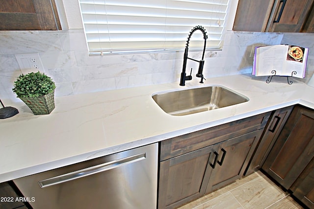 kitchen featuring dark brown cabinetry, decorative backsplash, sink, and stainless steel dishwasher