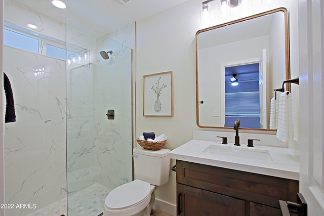 bathroom with vanity, toilet, and a tile shower