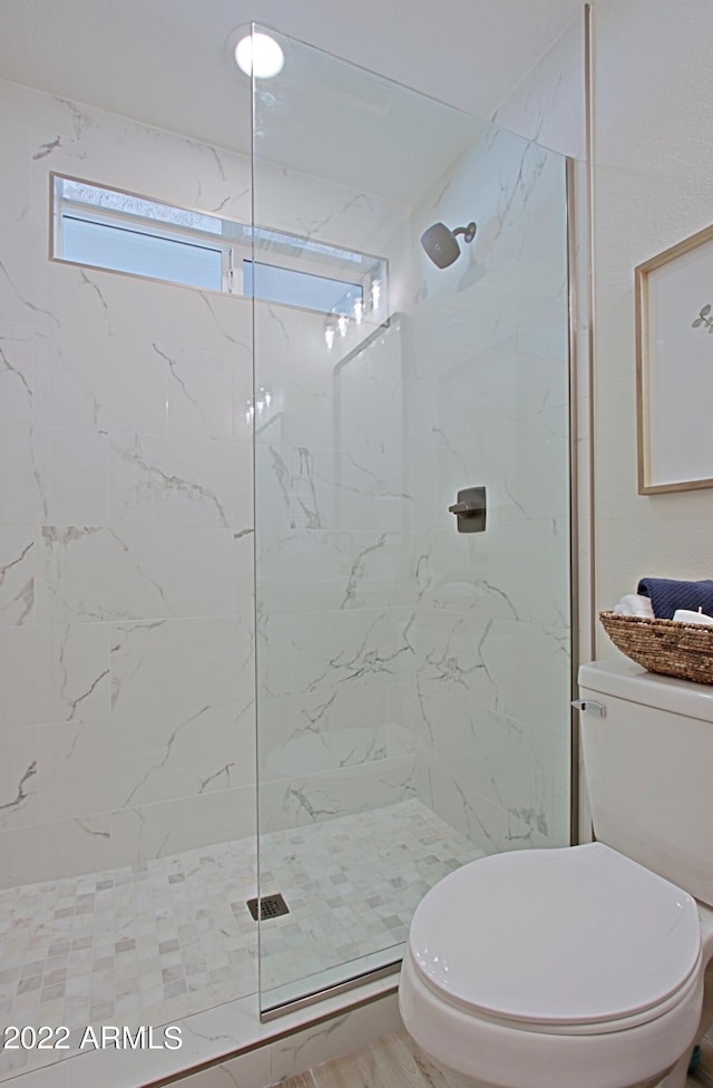 bathroom featuring toilet and tiled shower