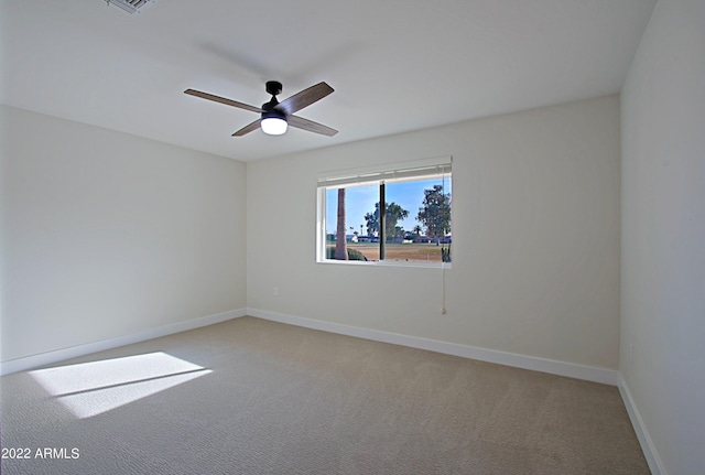 carpeted spare room with ceiling fan