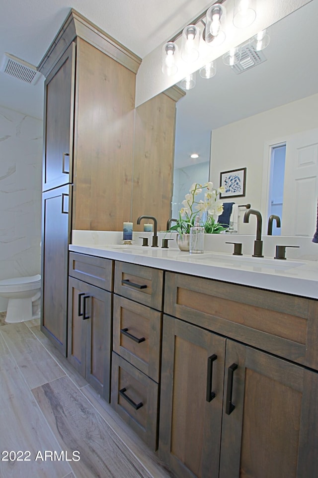 bathroom with vanity, toilet, and hardwood / wood-style floors