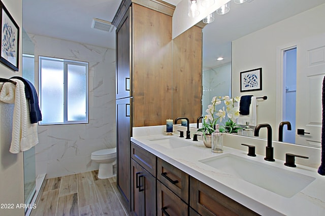 bathroom featuring toilet, walk in shower, tile walls, vanity, and hardwood / wood-style flooring