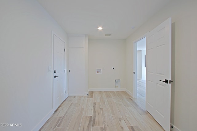 laundry room with hookup for a washing machine, light hardwood / wood-style floors, and electric dryer hookup