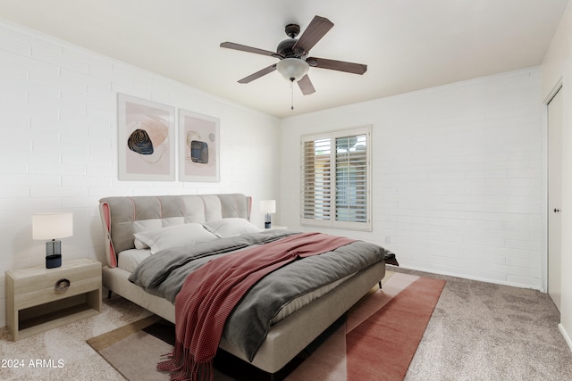 bedroom with light carpet, ceiling fan, and brick wall