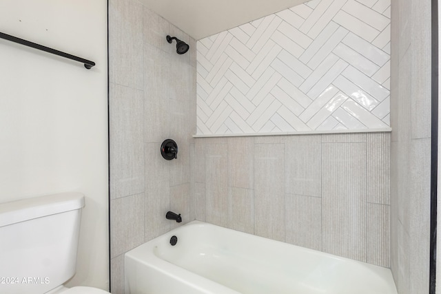 bathroom featuring toilet and tiled shower / bath