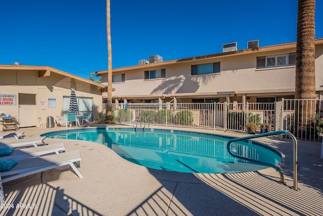 view of pool with cooling unit and a patio area