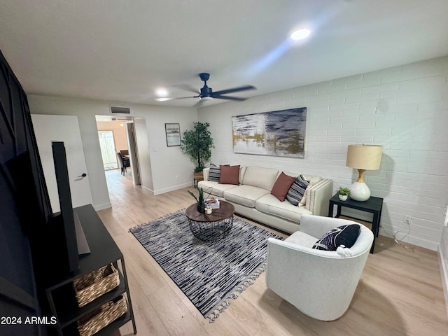 living room featuring ceiling fan and light hardwood / wood-style flooring