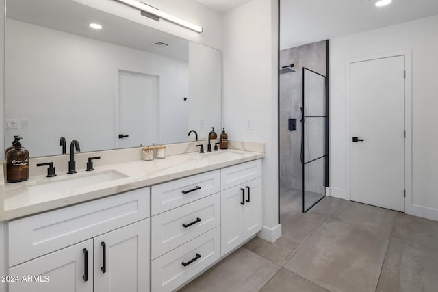 bathroom with a tile shower and vanity