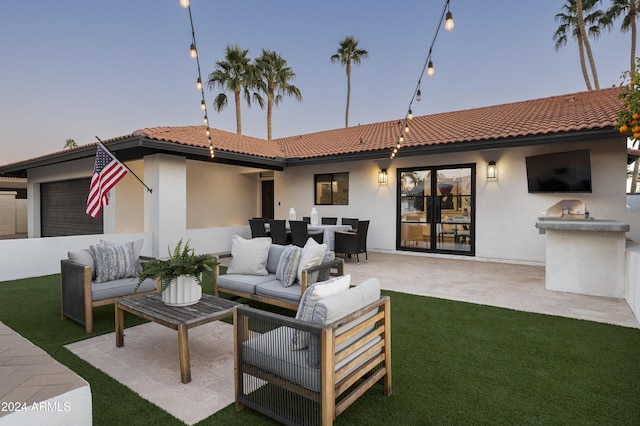 patio terrace at dusk featuring an outdoor living space and area for grilling