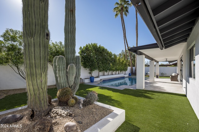 view of yard with a fenced in pool, ceiling fan, and a patio