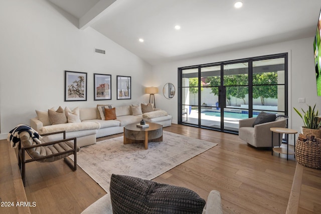 living room with lofted ceiling with beams and hardwood / wood-style flooring