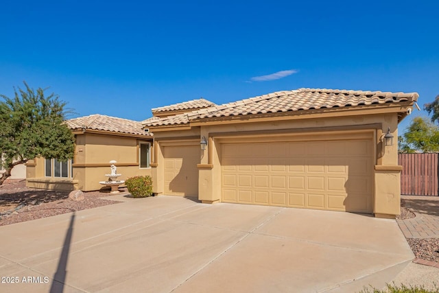 view of front of house with fence, an attached garage, stucco siding, concrete driveway, and a tile roof