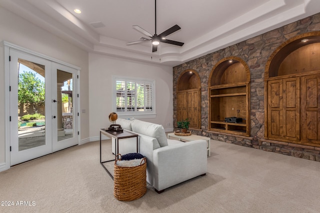 carpeted living room featuring french doors, ceiling fan, and a tray ceiling