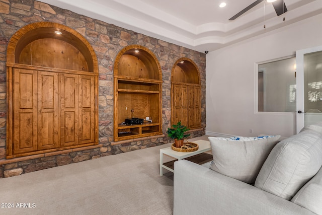 living room featuring ceiling fan, a raised ceiling, and carpet