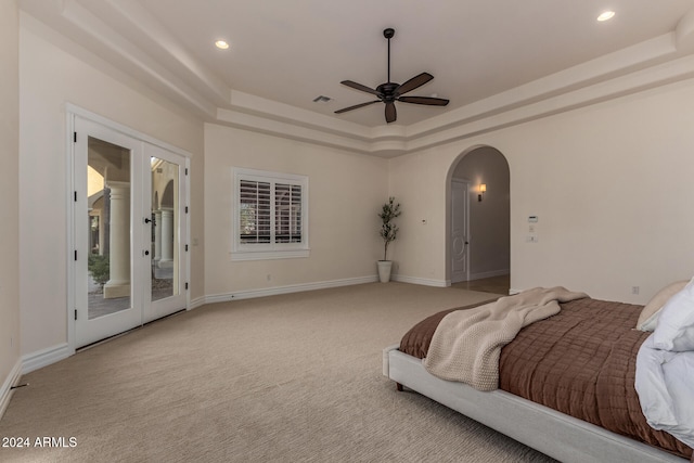 carpeted bedroom featuring french doors, access to outside, ceiling fan, and a raised ceiling