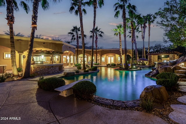 pool at dusk featuring a patio